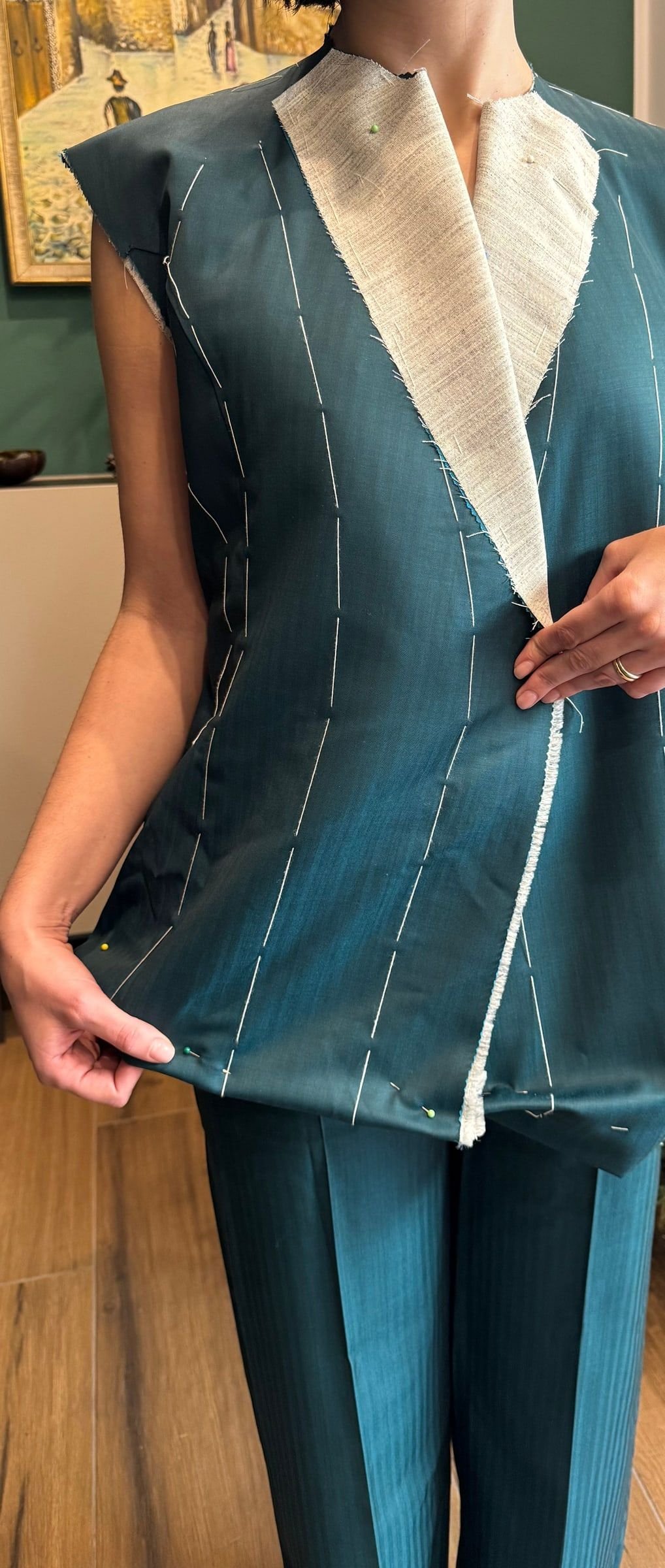 Prova di una giacca di tailleur imbastita, con la tela a vista
